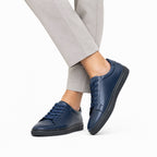 Sneaker Noir – portée avec pantalon beige vue de face en marche