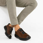 Slip-On Noir – porté avec pantalon gris vue latérale en marche