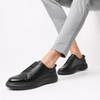 Slip-On Cognac – porté avec pantalon gris vue latérale en marche