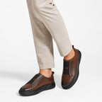Slip-On Cognac – porté avec pantalon beige vue de face en marche