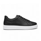 Sneaker Noir semelle blanche – portée avec pantalon gris vue de face assise